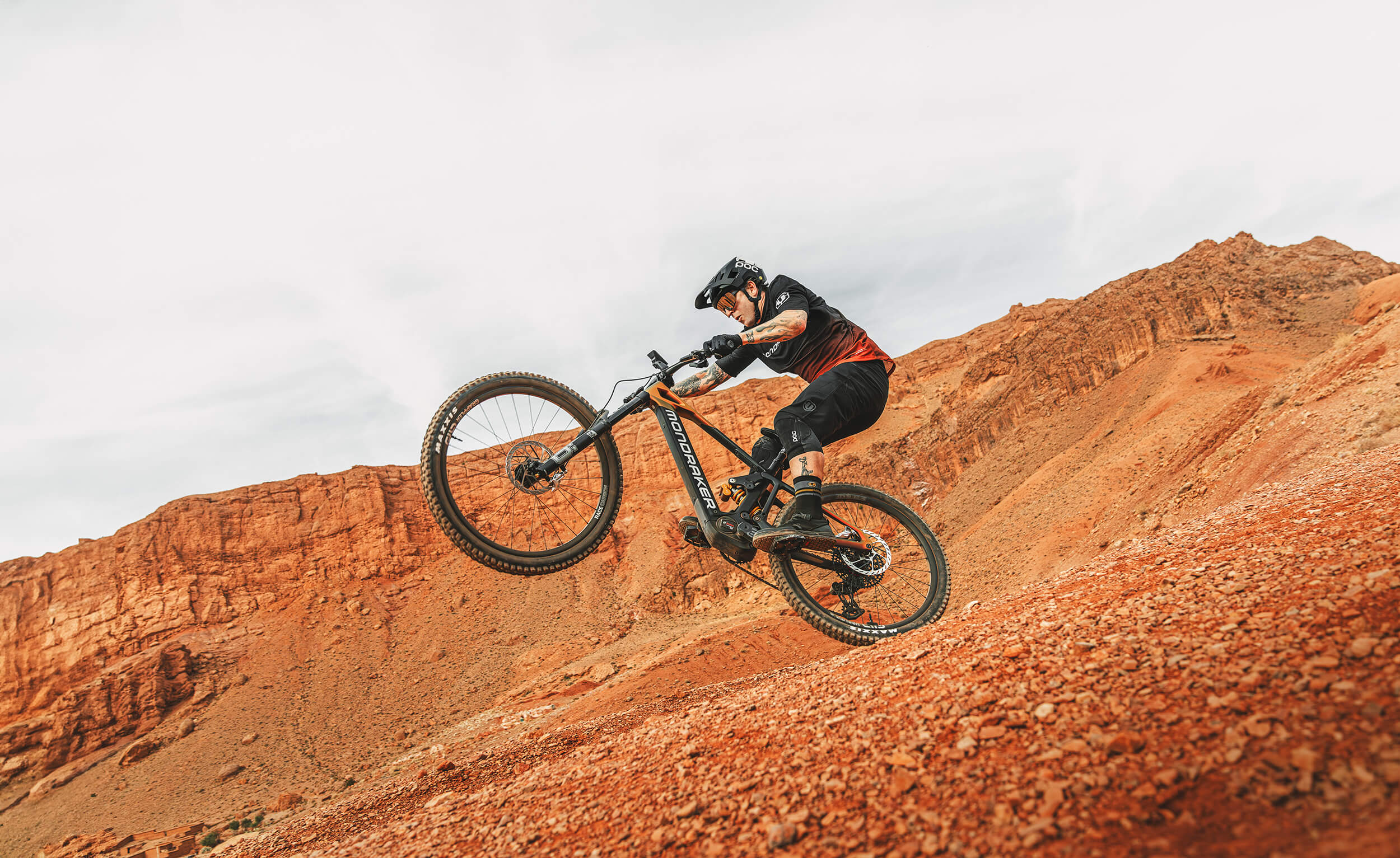 Mountainbiker mit Mondraker Dune in roter Wüstenlandschaft in Aktion. Ideal für Offroad-Fans und Abenteuerlustige.