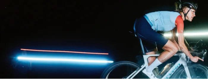 Frau fährt bei Nacht auf einem CERVELO Soloist mit sportlicher Kleidung. Vordergrundbeleuchtung und Geschwindigkeitseffekte.