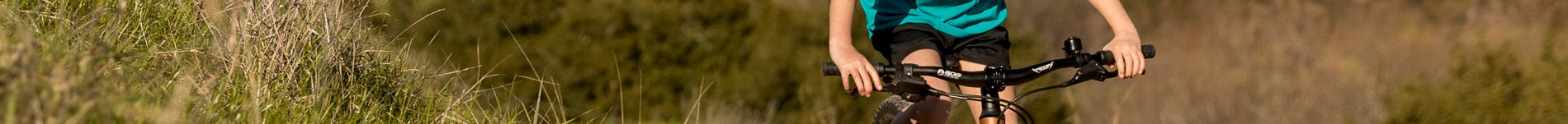 Kind auf Fahrrad mit schwarzem Lenker und grüner Wiese. Ideal für junge Radfahrer, geeignet für Outdoor-Aktivitäten.