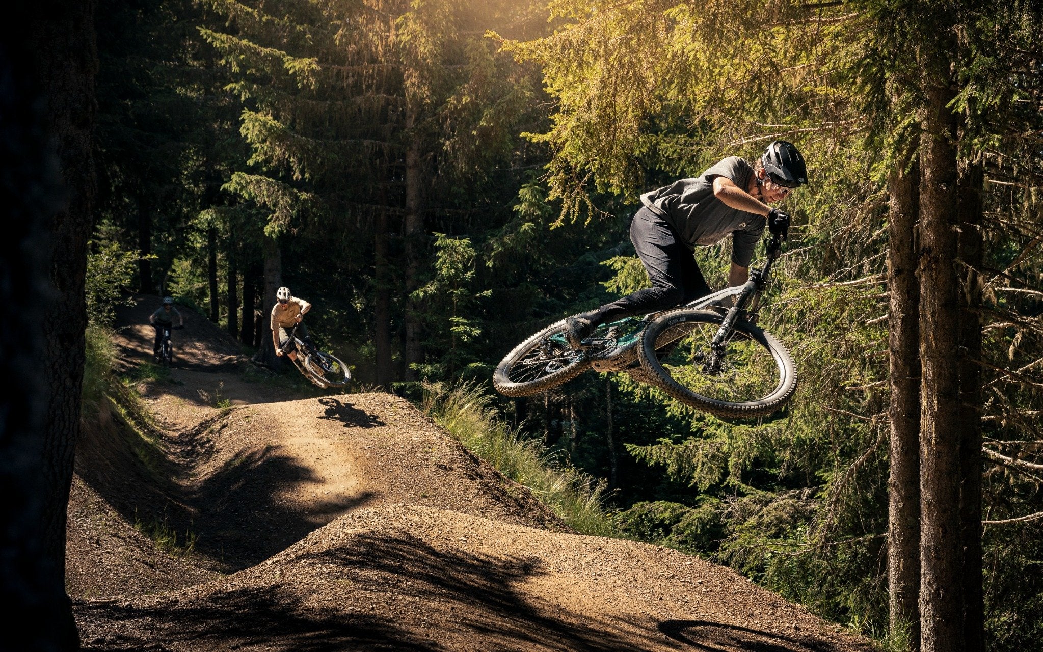 Zwei Mountainbiker fahren auf Wald-Trail mit E-MTBs der Serie Focus Jam2, perfekter Spaß für Outdoor-Enthusiasten.