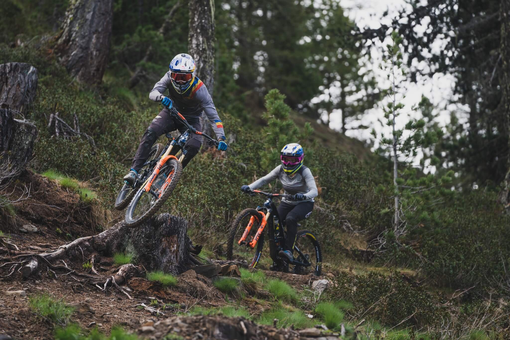 Zwei Mountainbiker auf einem steilen, bewaldeten Trail mit GT-Bicycles.