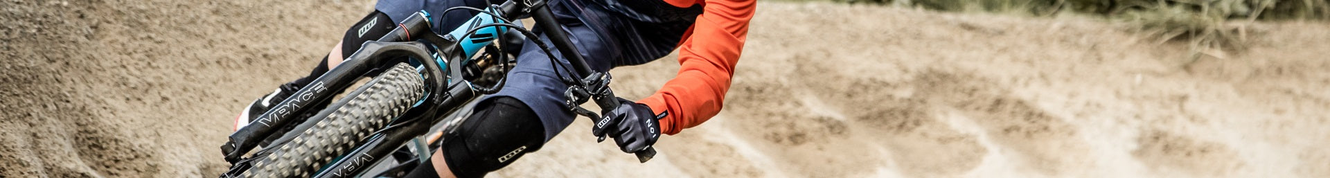 Mountainbiker mit VPACE-Fahrrad und ION-Knieschützern in Aktion. Ideal für Offroad-Abenteuer und Schutz.