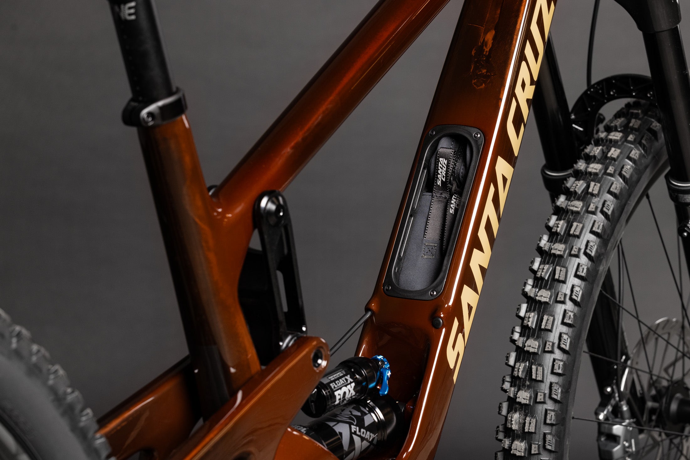 Santa Cruz Bronson Mountainbike in Dunkelbraun mit integriertem Werkzeugfach und robusten Reifen, Nahaufnahme des Rahmens.