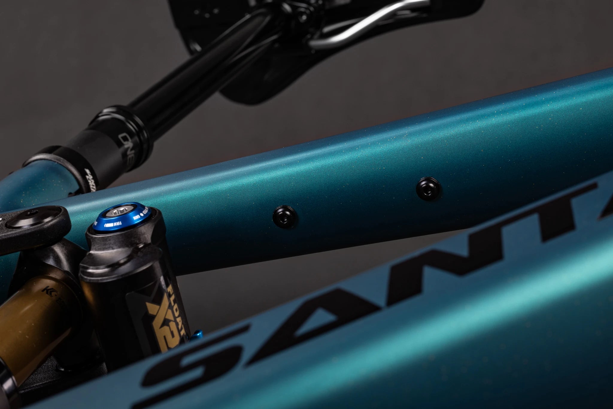 Detailansicht eines türkisfarbenen Santa Cruz Bullit Mountainbike-Rahmens mit Federungskomponenten.