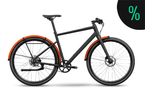 Schwarzes Urban-Bike mit orangenen Schutzblechen, Scheibenbremsen und minimalistischem Design, ideal für Stadtfahrten.