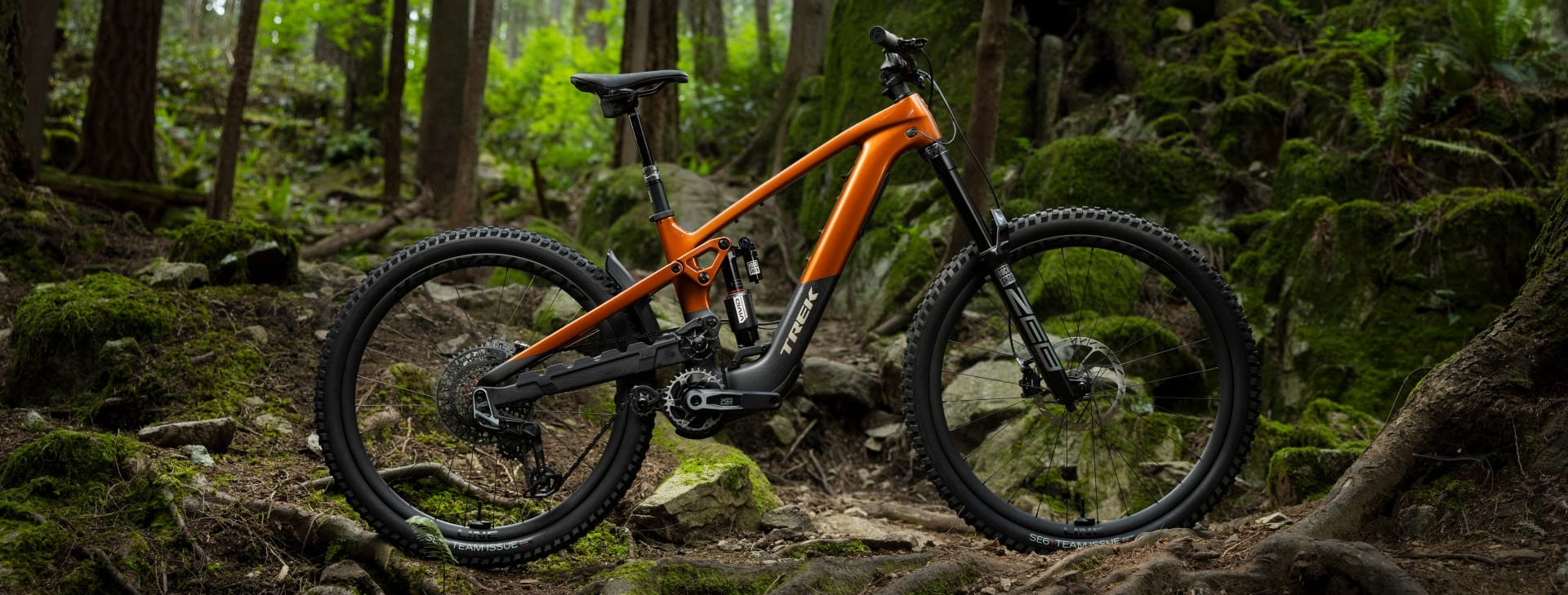 Orangefarbenes Trek Mountainbike im Wald, geeignet für Geländefahrten und Outdoor-Abenteuer.