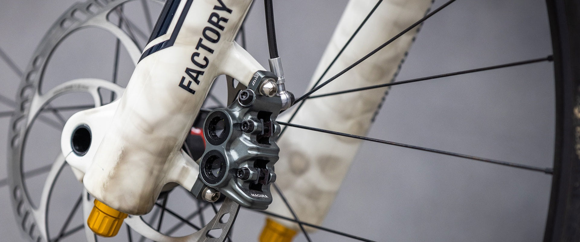 Magura Gustav M Pro-Bremse an einem Fahrrad, geeignet für Mountainbikes, mit silbernen Bremsscheiben und weißen Gabeln.