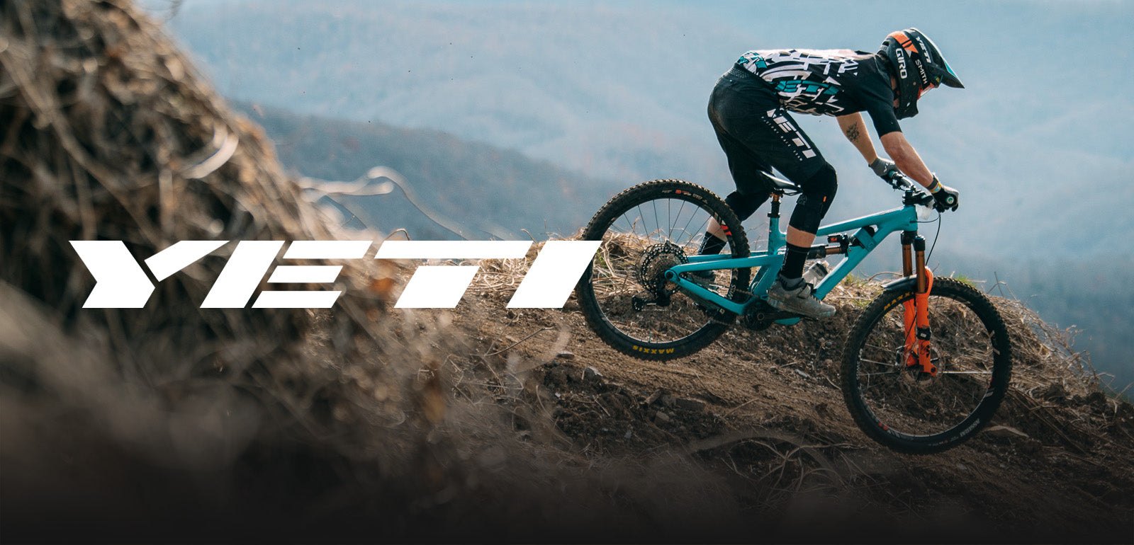 Mountainbiker auf blauem Yeti-Fahrrad bewältigt Abhang, geeignet für Offroad-Enthusiasten.