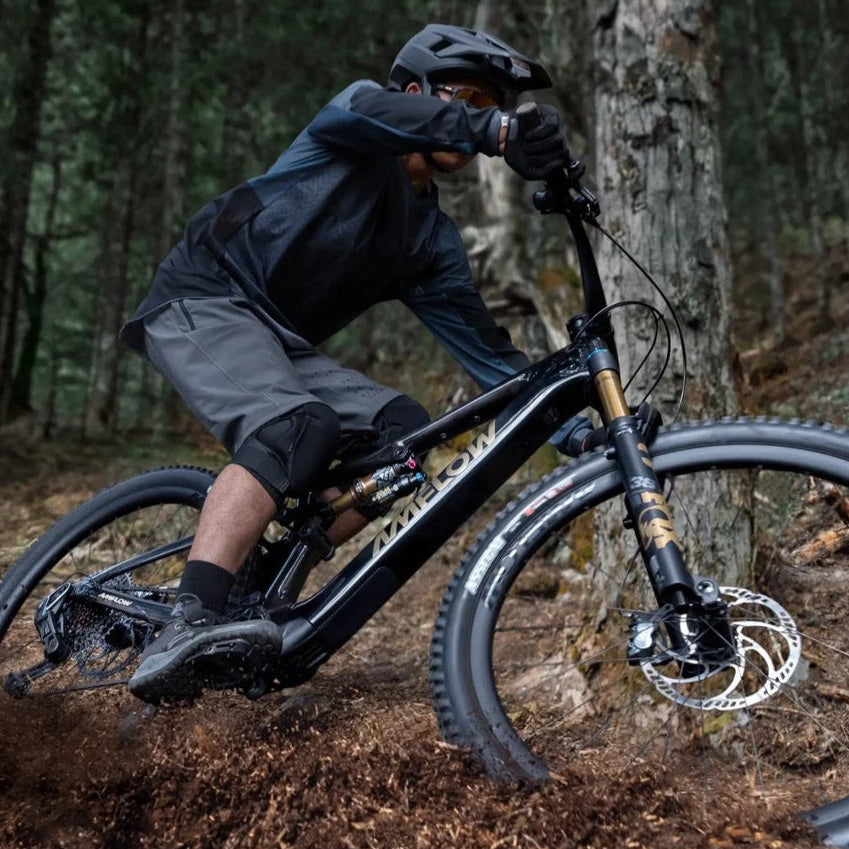 Mountainbiker auf Amelow E-Bike im Wald, offroad, mit Helm und Schutzkleidung; für sportliche Outdoor-Abenteuer geeignet.