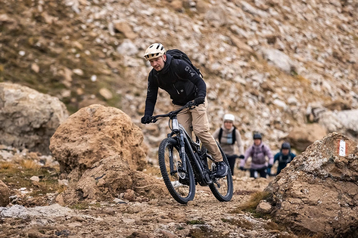 Mann auf Mountainbike in felsigem Gelände, Fokus auf Abenteuer und Outdoor-Fitness.
