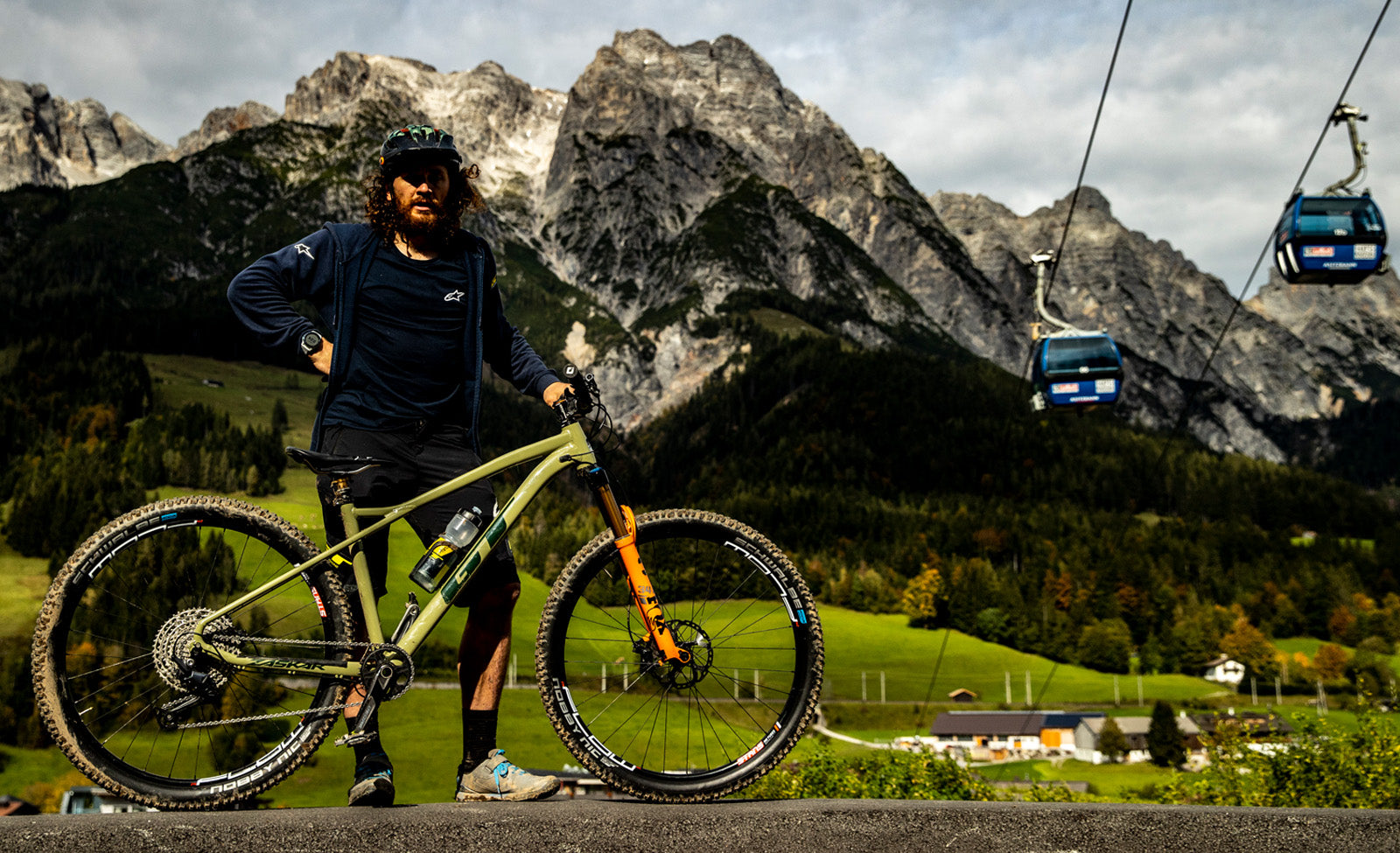 Person mit einem GT-Mountainbike vor alpiner Kulisse; geeignet für Offroad-Radfahren in Berglandschaften.