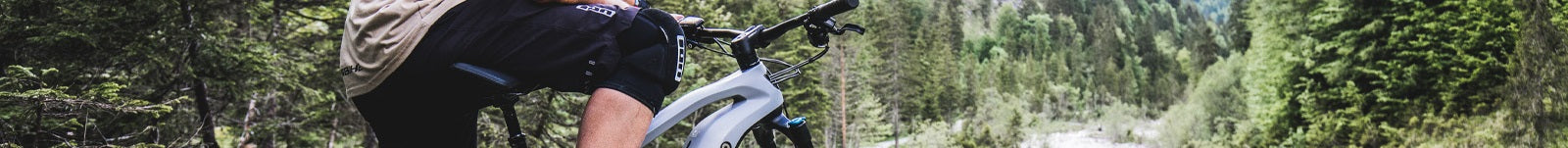 Ein Mountainbiker fährt ein Haibike im Wald, ideal für Offroad-Touren; Fokus auf Fahrradrahmen und Lenker.