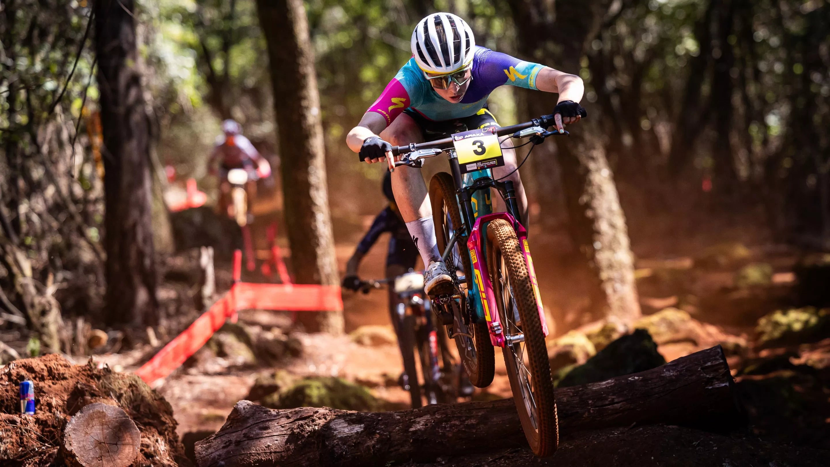 Mountainbiker auf Specialized S-Works Bike im Rennen durch einen Waldpfad, staubige und anspruchsvolle Strecke.