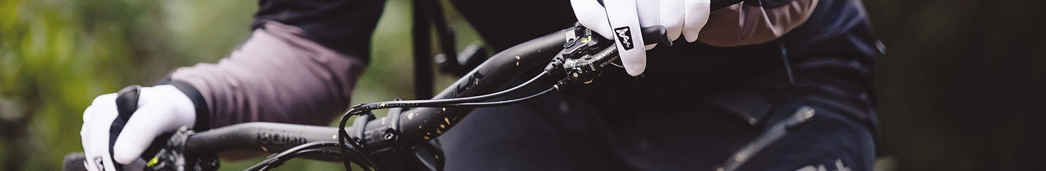 Mountainbiker mit weißen Handschuhen hält SQLab-Lenker, ideal für sportliche Fahrrad-Enthusiasten.