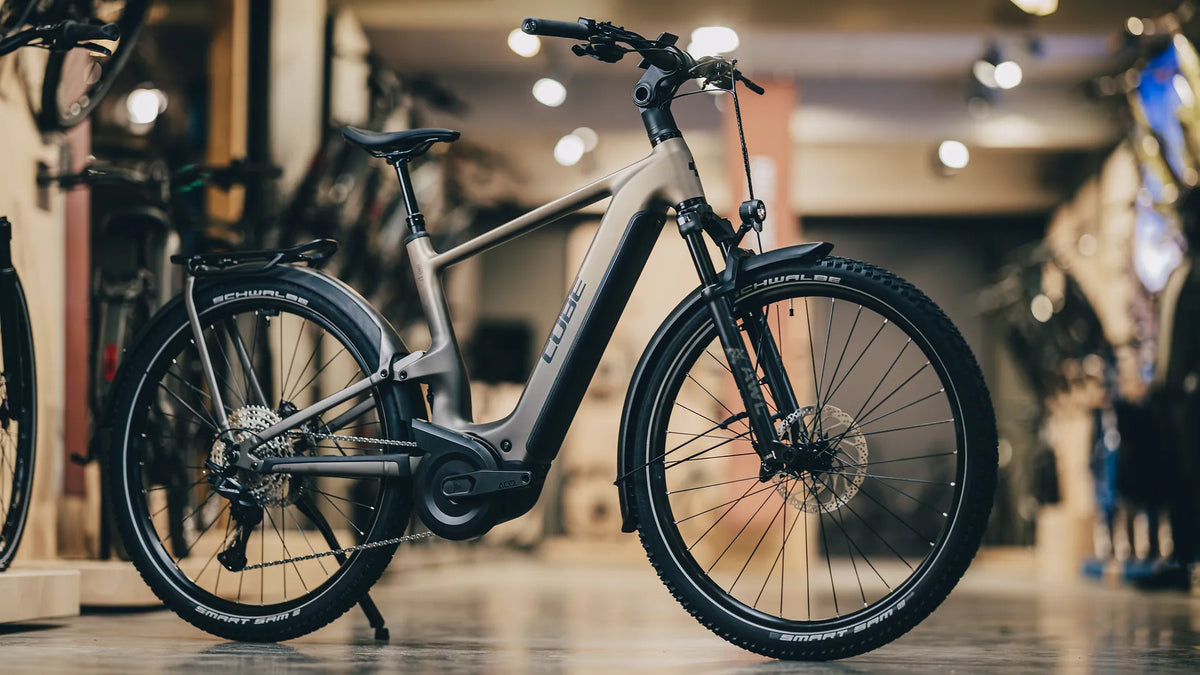 E-Bike Cube NURIDE HYBRID ONE11 HPC SLX 800 mit stabilen Reifen und Gepäckträger, geeignet für Stadtfahrten und Trekking.