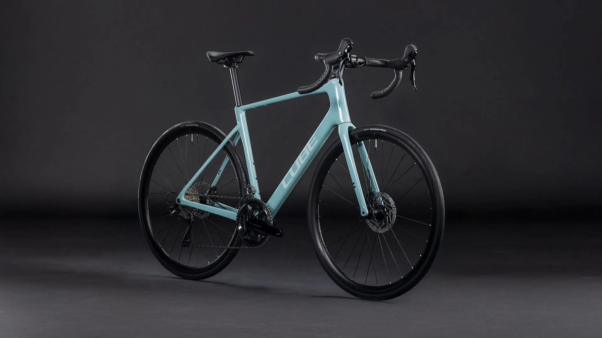 Blaues Cube Attain Race Rennrad mit schwarzem Rahmen und Scheibenbremsen, geeignet für sportliche Radfahrer auf der Straße.
