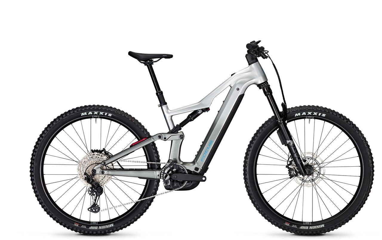 Silbernes Focus E-Mountainbike mit Vollfederung und Maxxis-Reifen, geeignet für Offroad-Abenteuer und sportliche Fahrer.