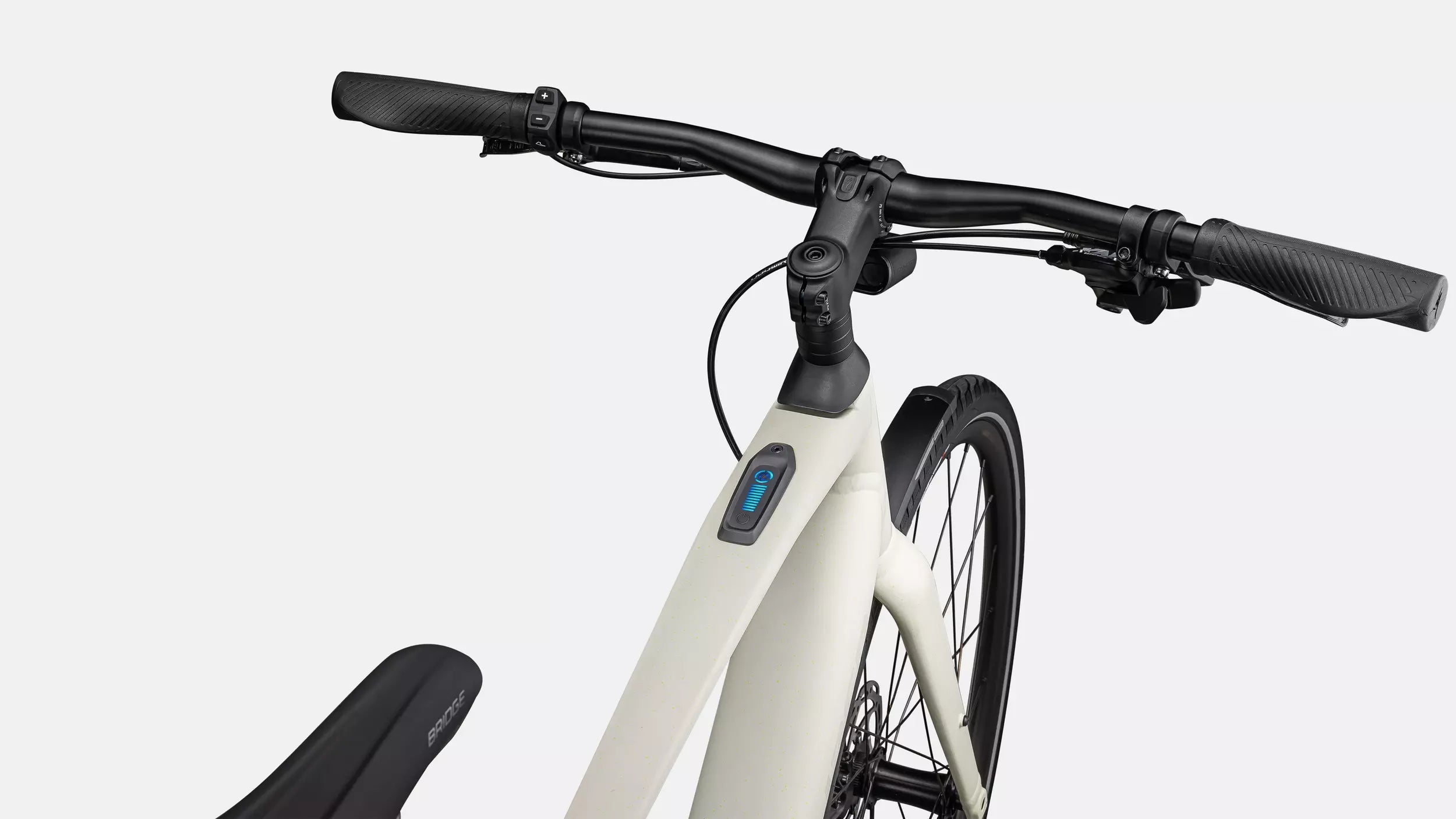 Lenker und Oberrohr eines weißen Specialized Turbo Vado E-Bikes, ideal für den Stadtverkehr.