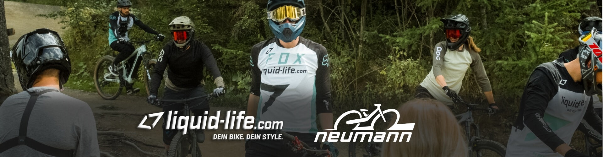 Mountainbiker im Wald, mit Helm und Schutzbrille, tragen „liquid-life.com“ und „Neumann“ Kleidung, vorbereitet fürs Gelände.