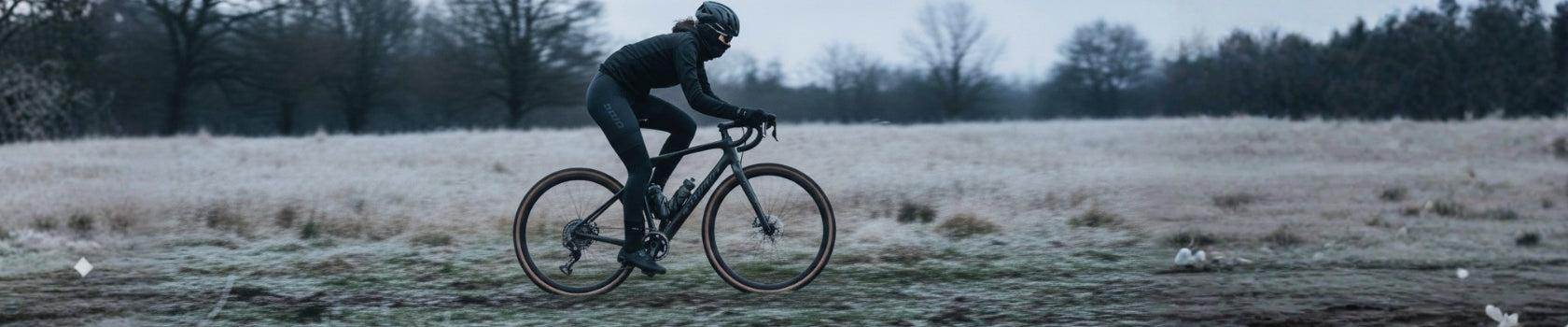Radfahrer auf einem Gravelbike fährt im Winter durch eine frostige Landschaft.
