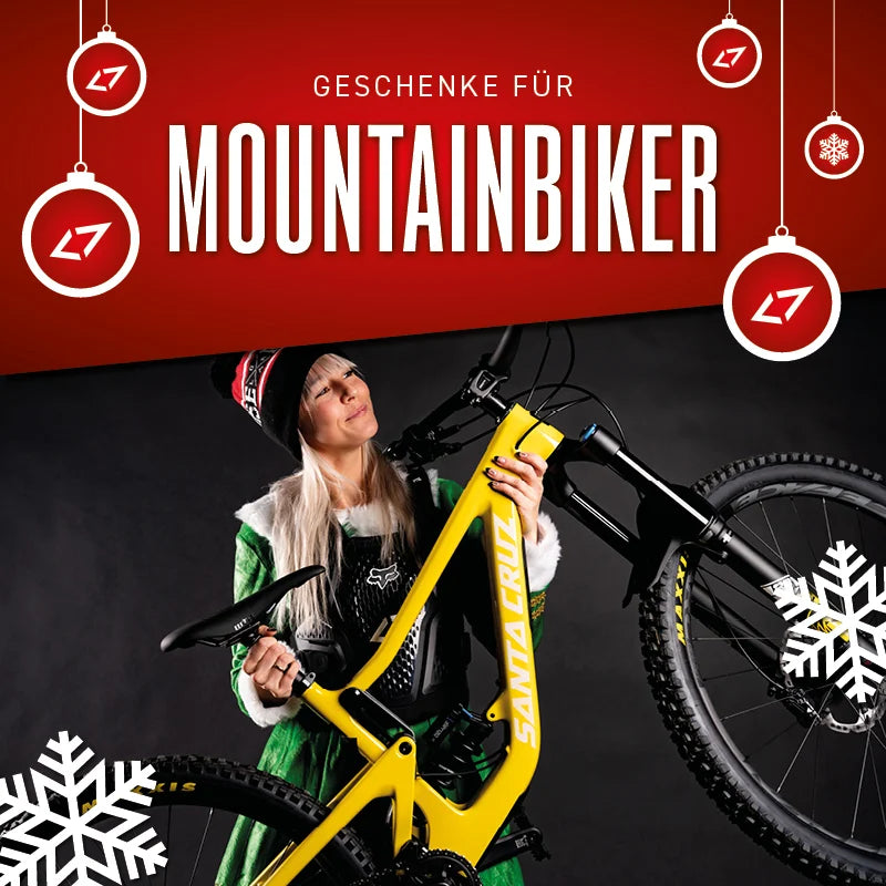 Frau in Weihnachtskostüm mit Santa Cruz Mountainbike, umgeben von weihnachtlicher Dekoration. Ideal als Geschenkidee.