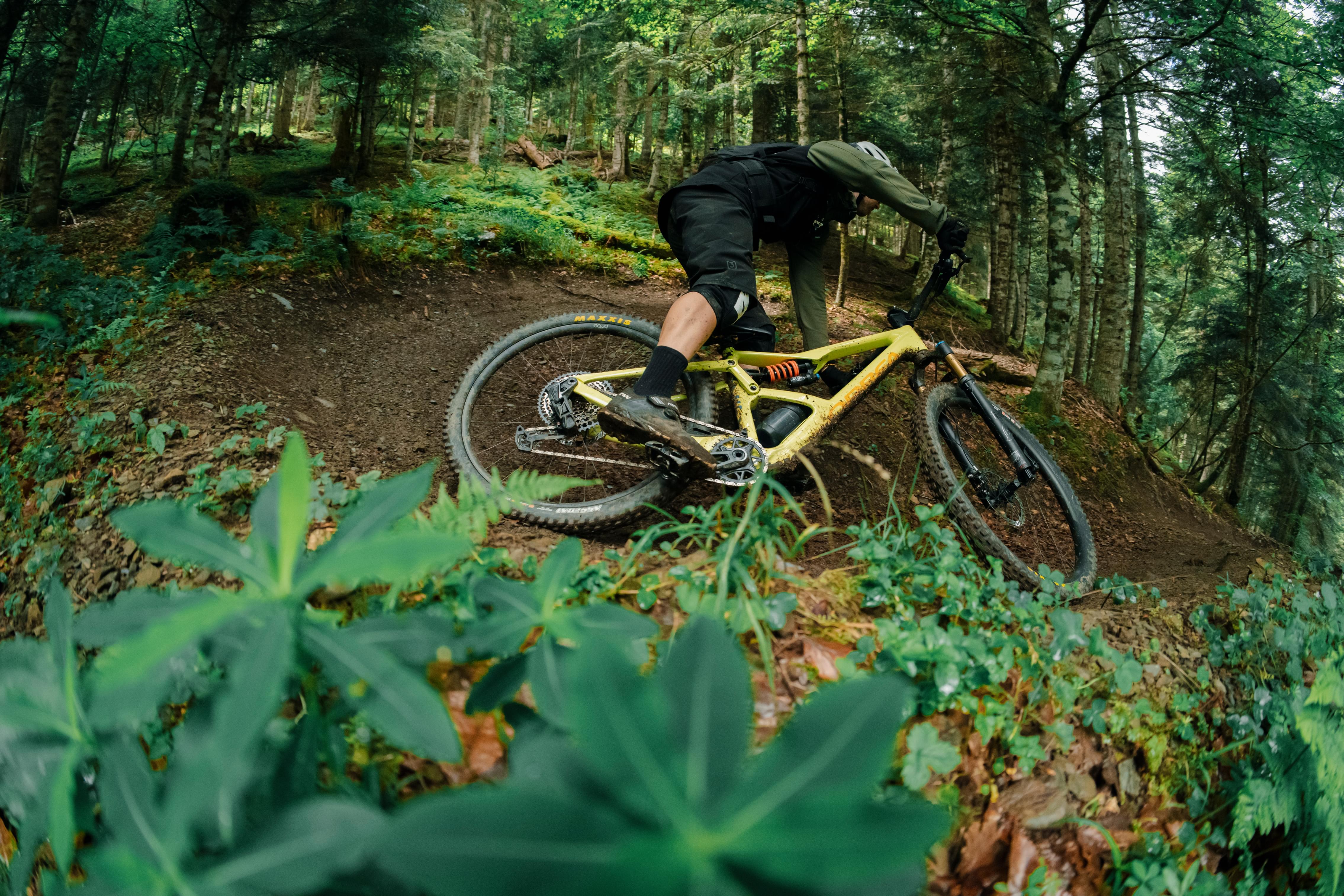 Mountainbiker fährt Orbea Occam Fahrrad in Kurve im Wald, ideal für Offroad-Abenteuer und Outdoor-Enthusiasten.