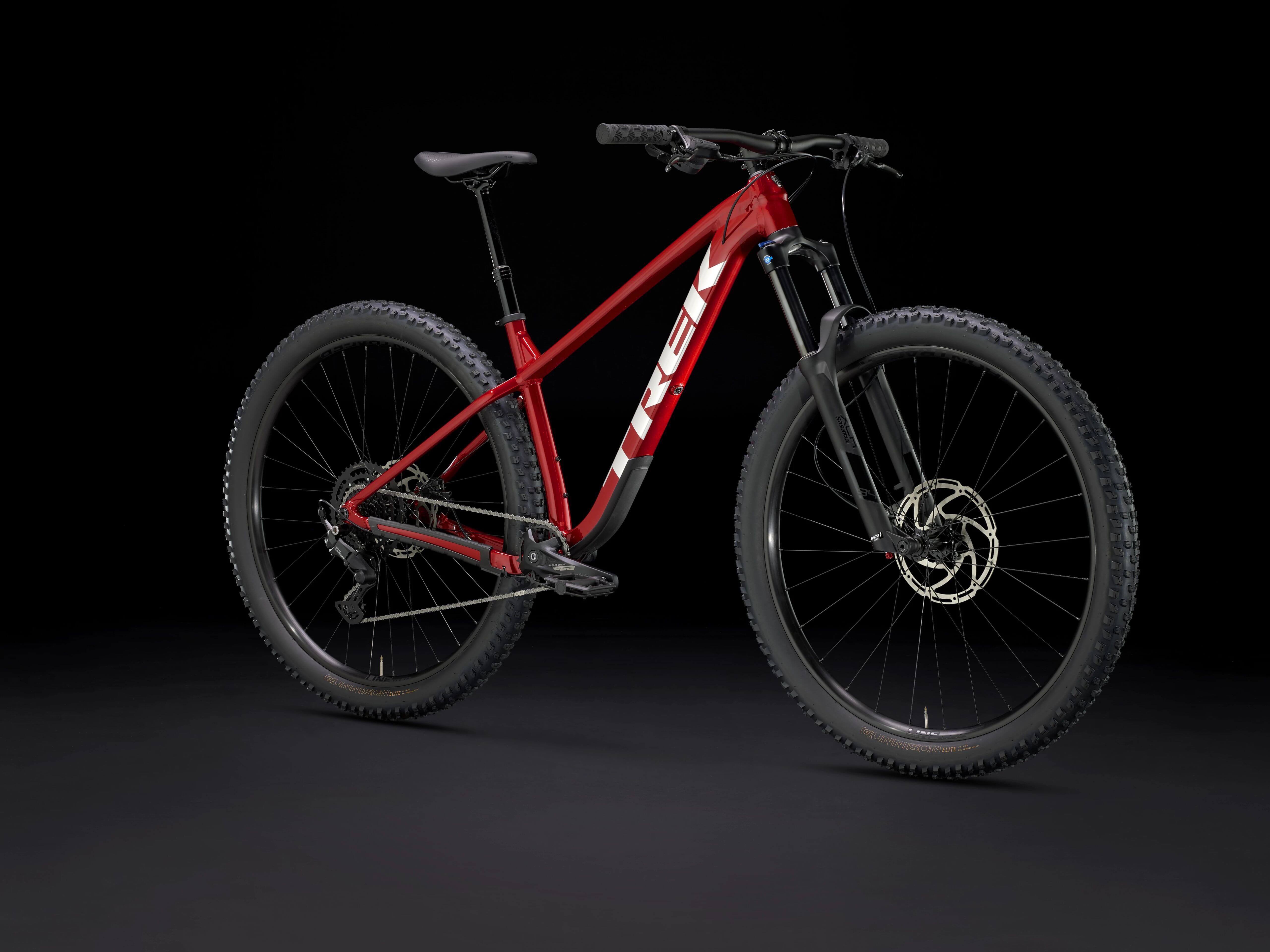 Rotes Trek Roscoe Mountainbike vor schwarzem Hintergrund, geeignet für Outdoor-Abenteuer und Mountainbiking.