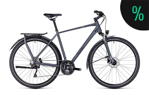Graues Citybike mit Gepäckträger und Scheibenbremsen, ideal für den Stadtverkehr. Prozentzeichen in der Ecke.