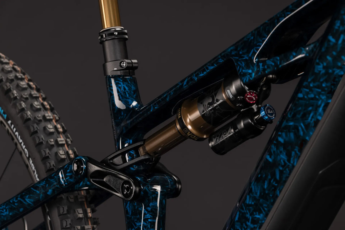 Nahaufnahme eines STEREO HYBRID ONE44 HPC SLT 800
mit blauen Mountainbike-Dämpfers mit Federungsdetails auf dunklem Hintergrund. Zielgruppe: Mountainbiker.
