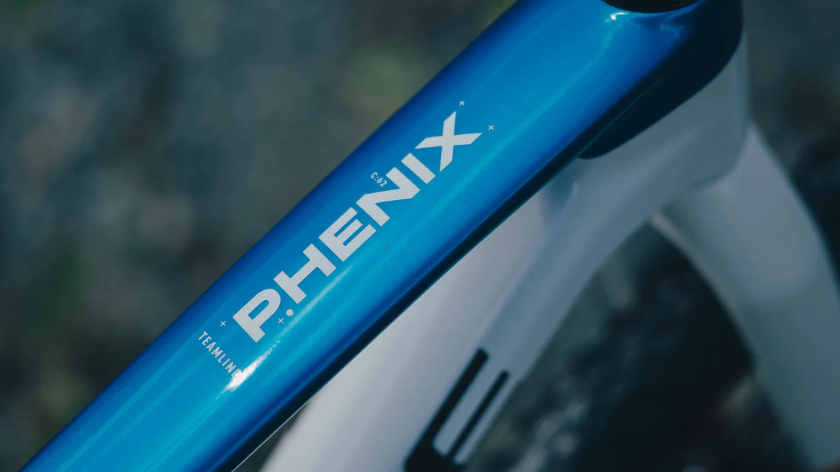 Nahaufnahme eines blauen PHENIX 240 C:62 SLX 2027 Fahrradrahmens mit der Aufschrift "PHENIX".