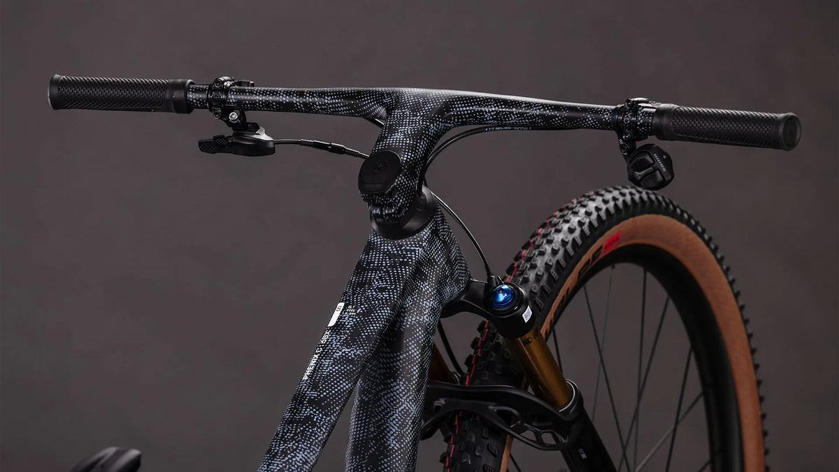 CUBE PHENIX C:68X SLX mit gemustertem Rahmen, breiten Reifen und Scheibenbremsen, geeignet für Offroad-Radfahren.