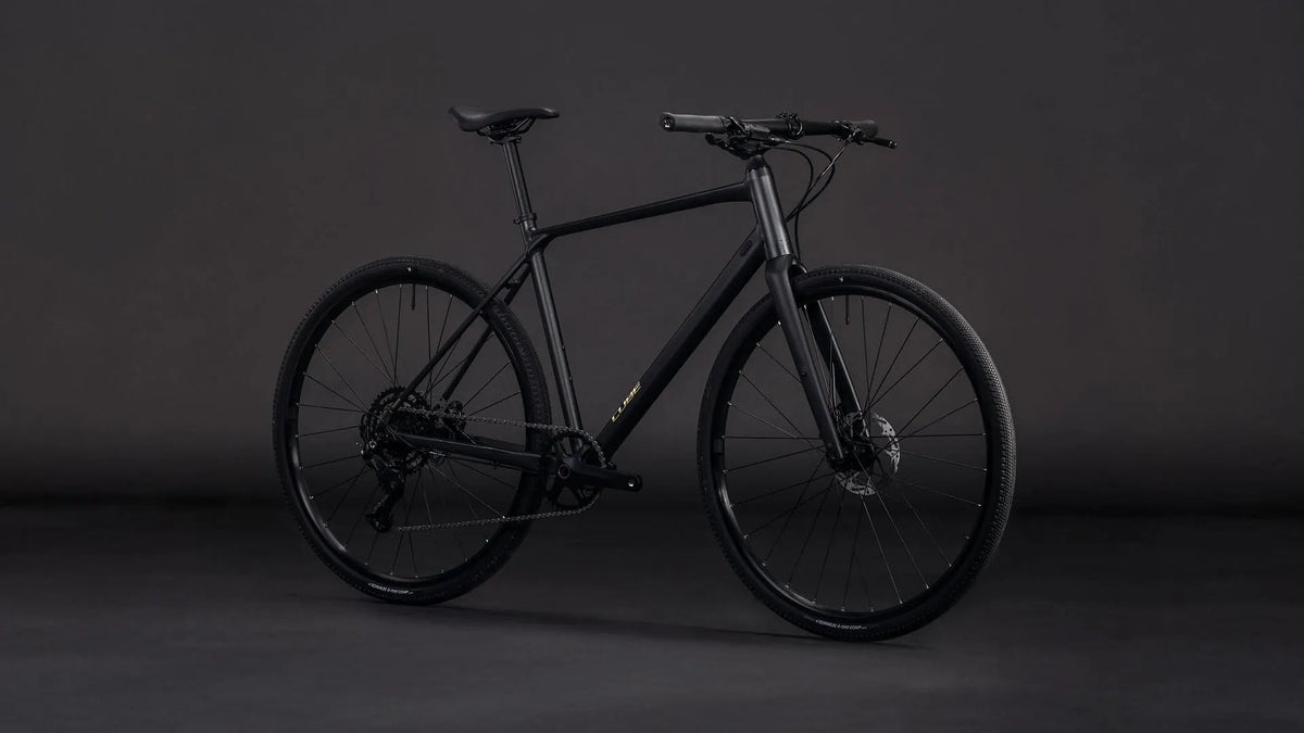 Schwarzes Cube NULANE PRO Modell ohne sichtbaren Schriftzug, auf grauem Hintergrund, geeignet für sportliche Fahrer.